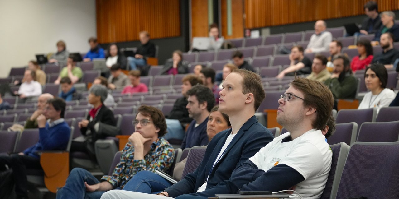 Photo of people sitting in an auditorium following a talk at ETAPS 2025.
